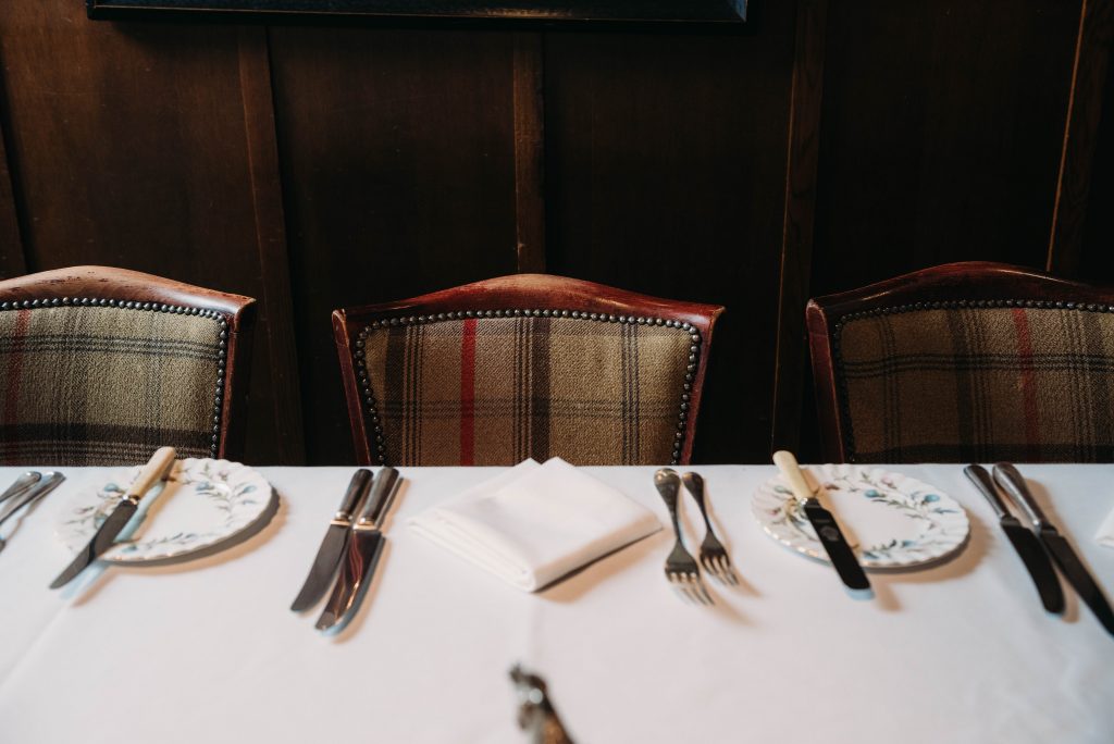 some chairs with a tartan design and table settings in front.