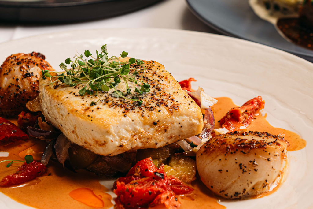 fillet of halibut with scallops, lobster bisque and sunblush tomatoes