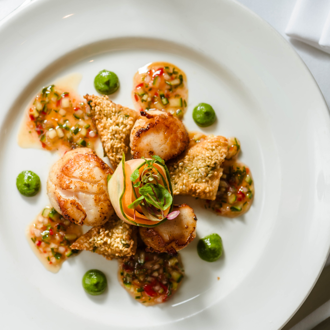 a plate of scallops with miniature prawn toast